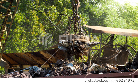 Big electric magnet sorting metal waste from other rubbish on scrapyard 66284972