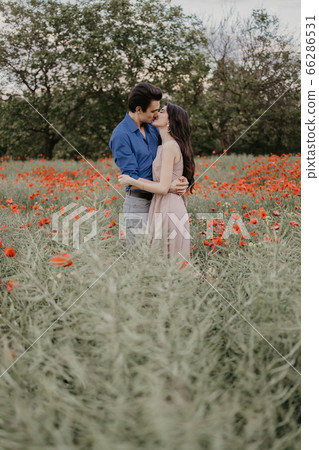 Happy couple in poppy fieldin summer time Happy couple in poppy fieldin summer time 66286531