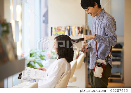 Hairdresser Young male hairdresser doing a cut 66287453