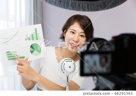 A woman shooting a video with an SLR camera 66291563