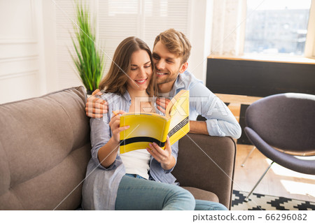 Young woman studying before exam, her husband hugging her and smiling 66296082