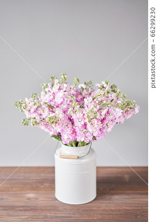 Bouquet of Beautiful lilac mattiola. Spring flowers in vase on wooden table. Flowers delivery. 66299230