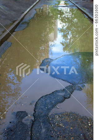 The bad asphalted road. Big pothole with water. 66301600