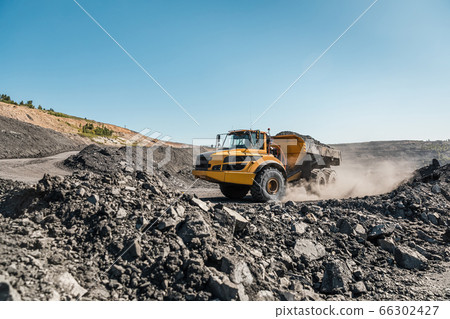 Large quarry dump truck. Loading the rock in dumper. Loading coal into body truck. Production useful minerals. Mining truck mining machinery, to transport coal from open-pit excavator work 66302427