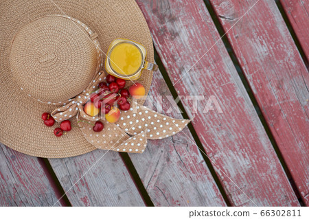 Glass of tropical exotic multifruit juice and fruits at the pier. Tropical beach picnic. 66302811