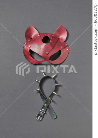 Leather collar with sharp spines and cat BDSM mask on a black background. Leather collar with sharp spines and cat BDSM mask on a black background. 66303270