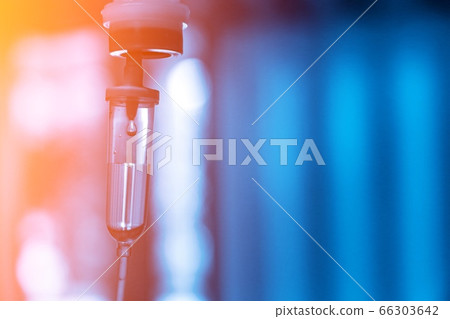 Chemotherapy drug medical holding hypodermic syringe needle injection iv bag fluid intravenous drop saline drip hospital room concept treatment  palliative care.selective focus.blue light background, 66303642