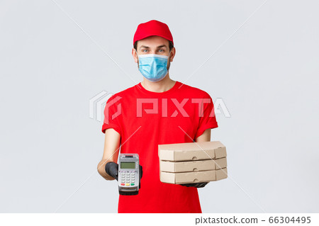 Food delivery, application, online grocery, contactless shopping and covid-19 concept. Friendly courier in red uniform, face mask and gloves, holding order pizza boxes and give client POS terminal Food delivery, application, online grocery, contactless shopping and covid-19 concept. Friendly courier in red uniform, face mask and gloves, holding order pizza boxes and give client POS terminal 66304495