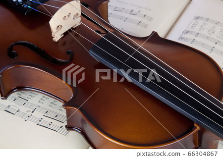 Violin resting on open sheet music book Violin resting on open sheet music book 66304867