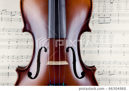 Violin on open old sheet music book 66304868