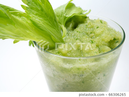 celery leaves and a glass of smoothies on a white 66306265