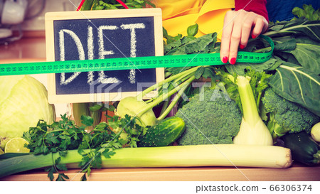 Woman in kitchen having green diet vegetables Woman in kitchen having green diet vegetables 66306374