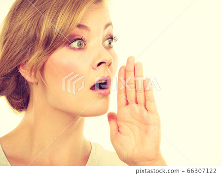 Woman whispering with hand close to mouth Woman whispering with hand close to mouth 66307122