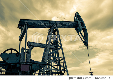 Petroleum concept. Oil pump rig. Oil and gas production. Oilfield site. Pump Jack are running. Drilling derricks for fossil fuels output and crude oil production. Global crisis. War on oil prices. 66308523