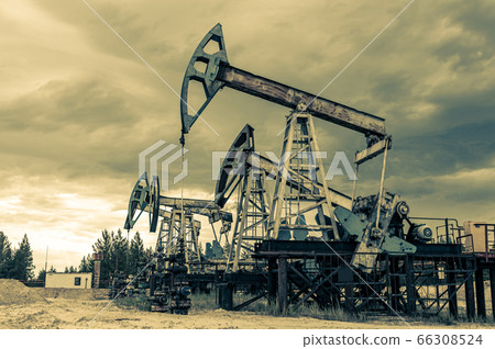 Petroleum concept. Oil pump rig. Oil and gas production. Oilfield site. Pump Jack are running. Drilling derricks for fossil fuels output and crude oil production. Global crisis. War on oil prices. 66308524