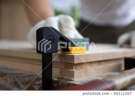 Male carpenter polishes wooden planks fixed vise 66312267