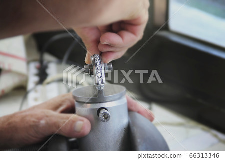 Jeweler mints silver decoration in workshop 66313346