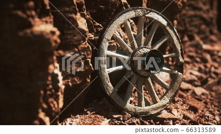 old wooden cart wheel on stone rocks old wooden cart wheel on stone rocks 66313589