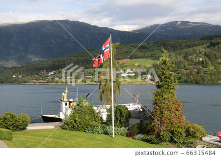 Norway Hardanger Fjord, Pleasure boat anchored in Ulvik district and Norwegian flag 66315484