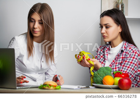Young woman visiting nutritionist in weight loss clinic 66316278