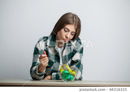 Young pretty woman adheres to diet with measuring tape on white wall background 66316335