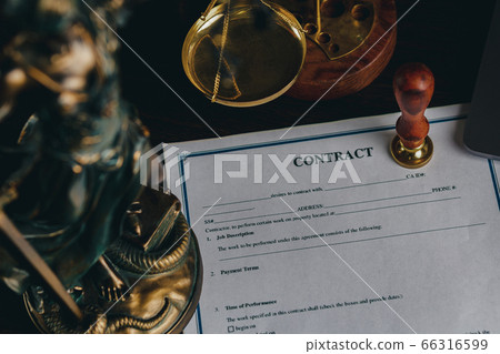 Top view of contract in clipboard lying at office on wooden table with laptop and documents Top view of contract in clipboard lying at office on wooden table with laptop and documents 66316599