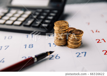Calendar, calculator and stack of coins in a office Calendar, calculator and stack of coins in a office 66316622