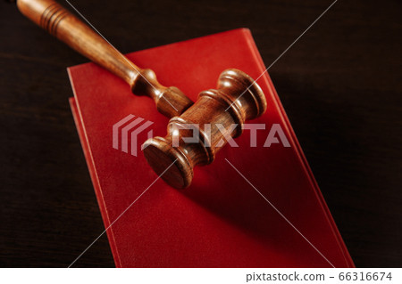 law book with a judges gavel resting on top of the pages in a courtroom or law enforcement office law book with a judges gavel resting on top of the pages in a courtroom or law enforcement office 66316674