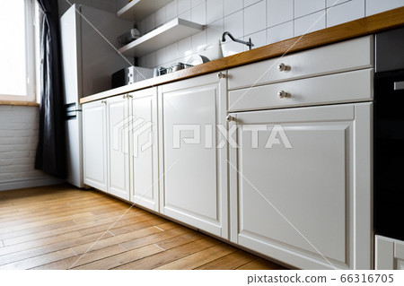 Appliances and furniture:bright white cabinets with wooden countertop in modern scandinavian kitchen 66316705