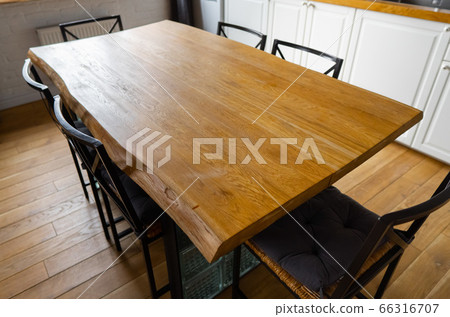 A big wooden dining table with metal wicker chairs in modern scandinavian an eat-in kitchen 66316707