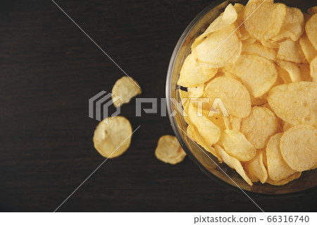 Plate of potato chips on the black table. Plate of potato chips on the black table. 66316740