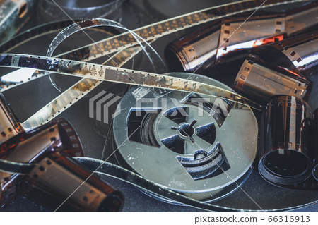 Old scratched 8 mm and 16mm film strips, bobbin, retro film and photo. Vintage background 66316913