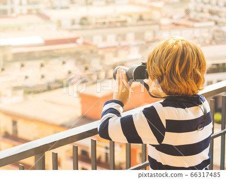 Blonde boy with binoculars exploring the city Blonde boy with binoculars exploring the city 66317485