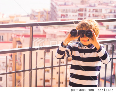 Blonde boy with binoculars exploring the city Blonde boy with binoculars exploring the city 66317487