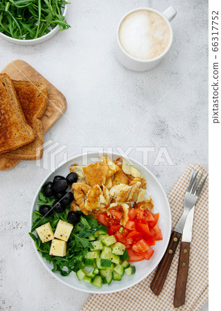 Fresh omelette for breakfast with mixed vegetables: rocket, tomatoes, cucumber, olives, cheese. Top view. Copy space. Fresh omelette for breakfast with mixed vegetables: rocket, tomatoes, cucumber, olives, cheese. Top view. Copy space. 66317752