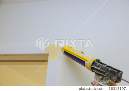 Worker hands on applying silicone sealant with 66318197