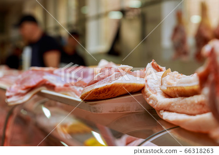 Showcase with raw meat pieces for a meat market in 66318263