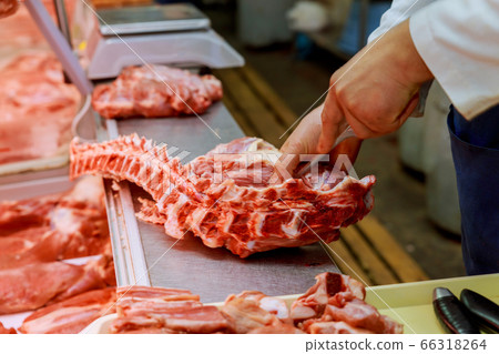 Preparing on shop butcher cutting meat at counter 66318264
