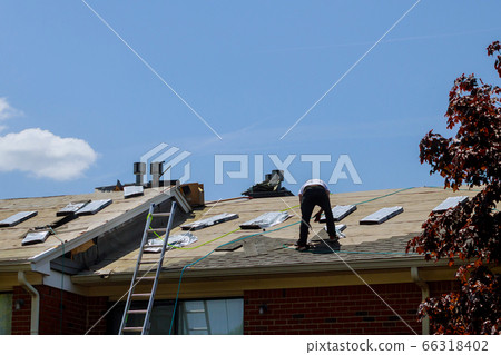 Roof repair, worker with replacing gray tiles 66318402