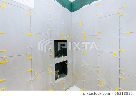 Bathroom construction laying floor and wall tile 66318855