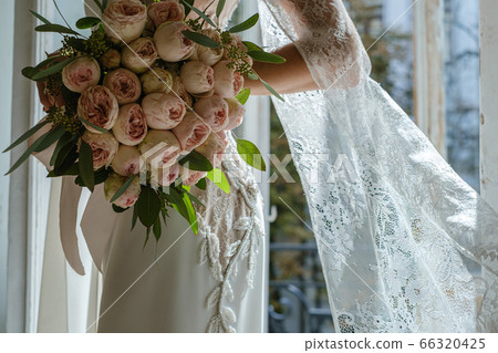 Wedding bouquet of pink peonies in hands of bride Wedding bouquet of pink peonies in hands of bride 66320425