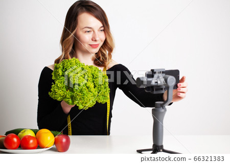 A young woman in lightroom writes a blog on weight loss and healthy eating 66321383