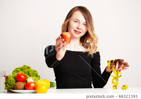 Healthy food, woman at the table with fresh vegetables and fruits eating right for weight loss 66321393