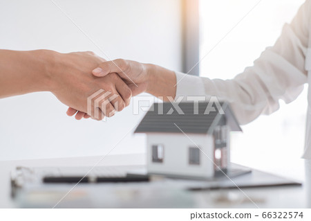 Estate agent in suit sitting in an office desk 66322574