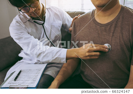 Asian doctor is using a stethoscope listen to the 66324147