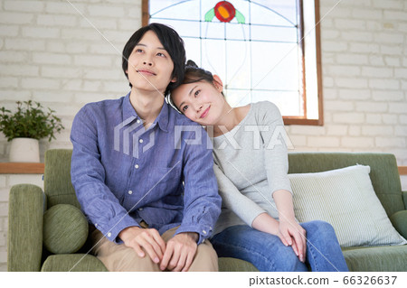Young couple cuddling on the sofa Young couple cuddling on the sofa 66326637