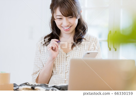 一個在跳蚤市場應用程序上賣衣服的女人 66330159