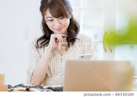 一個在跳蚤市場應用程序上賣衣服的女人 66330160