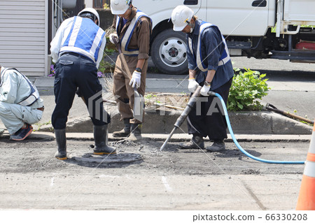 Worker cutting through asphalt on the road Worker cutting through asphalt on the road 66330208