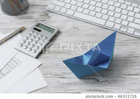 Office workspace with blue paper ship 66331726